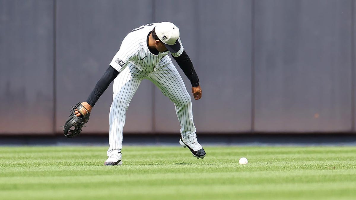 Yankees outfielder Trent Grisham bobbles the ball