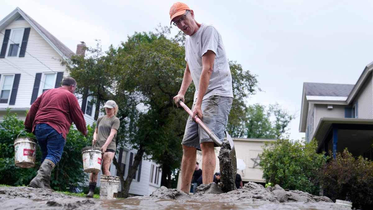 A Vermont resident shovels mud away from his home after Hurricane Beryl caused flooding.