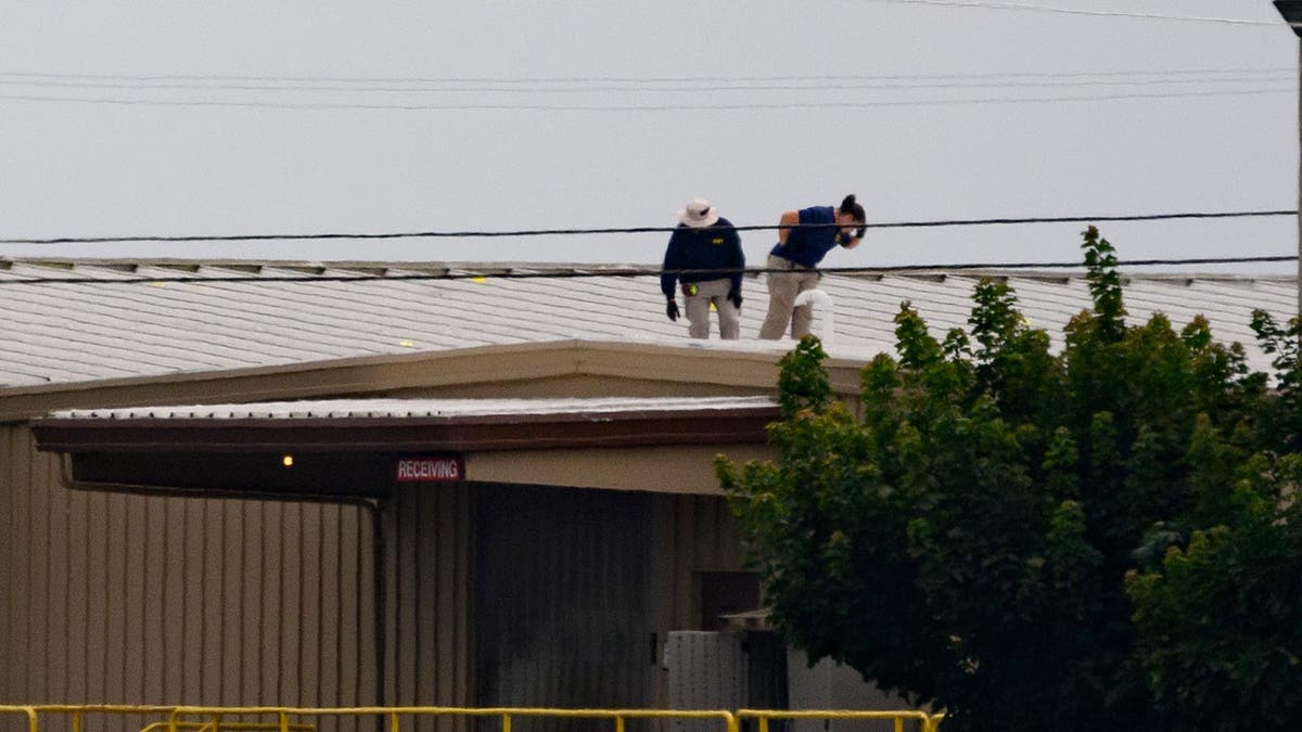 FBI investigators on the roof of the building where the would-be assassin shot at former president Donald Trump
