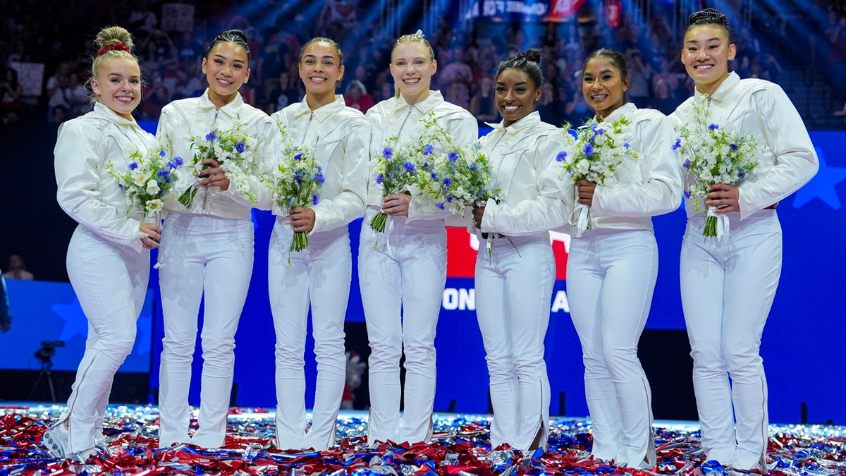 The newly named members of the 2024 United States Gymnastics Olympic team smiles.