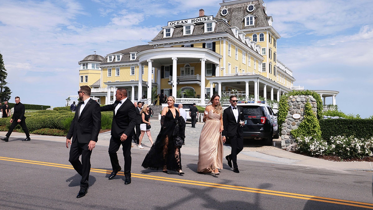 The Ocean House (a yellow colonial) in the background, guests of Olivia Culpo's wedding in front