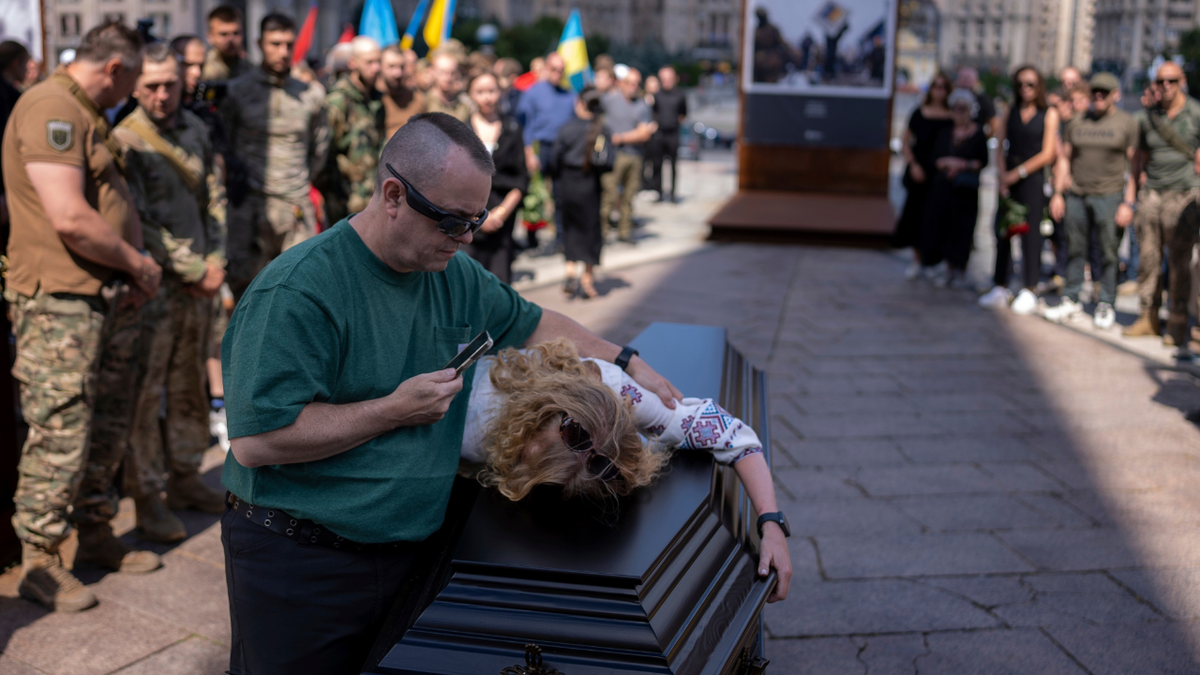 Partner of British combat medic, volunteer, Peter Fouche, 49 who was killed on June 27 during his work in East Ukraine, mourns during the funeral ceremony