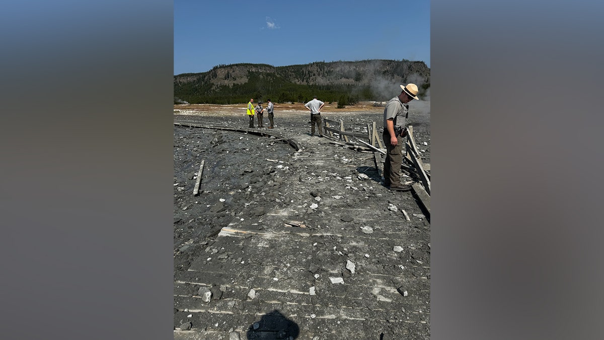 Los guardabosques del parque de Yellowstone examinan los escombros de la explosión