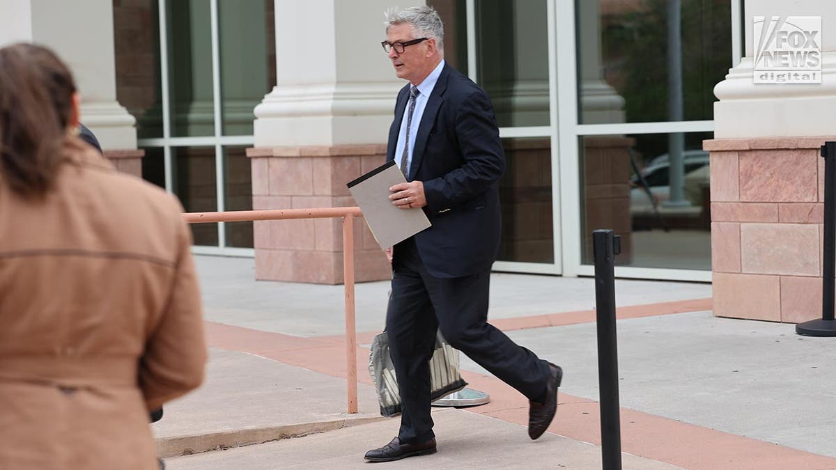 Alec Baldwin in a suit leaves court