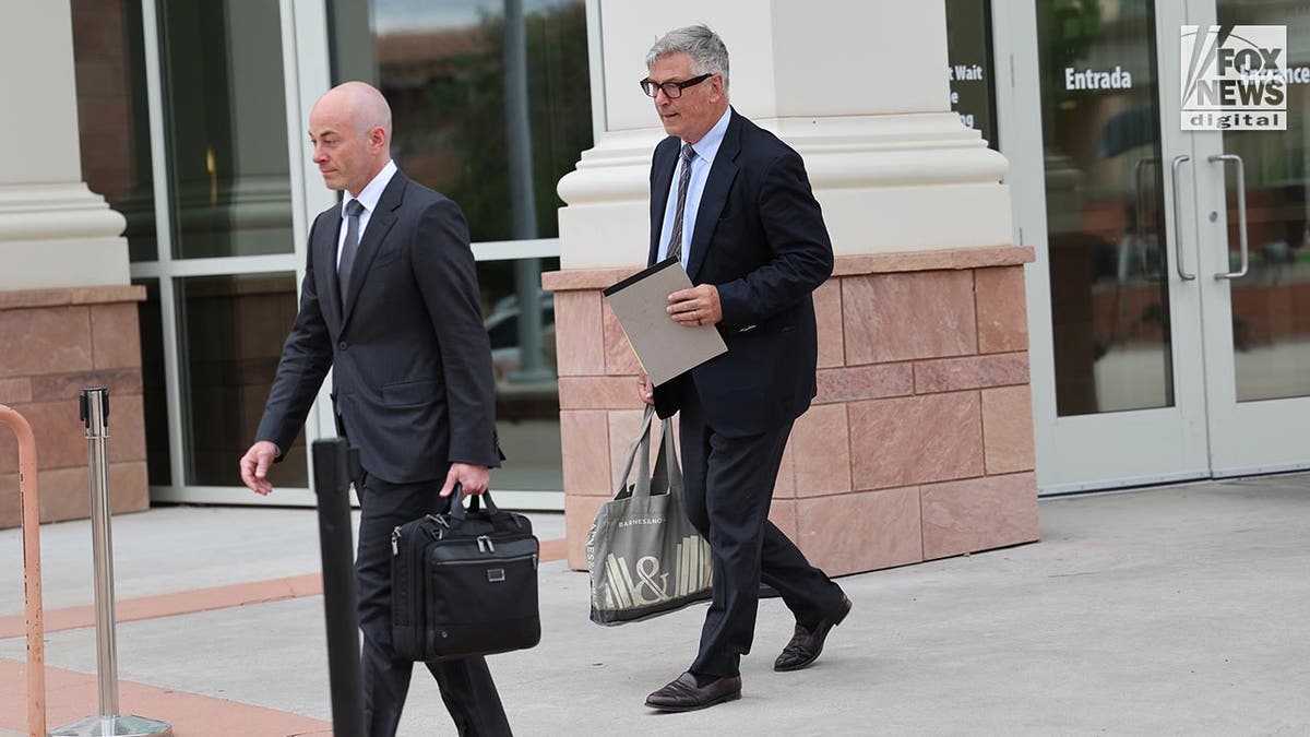 Alec Baldwin in a suit leaves court
