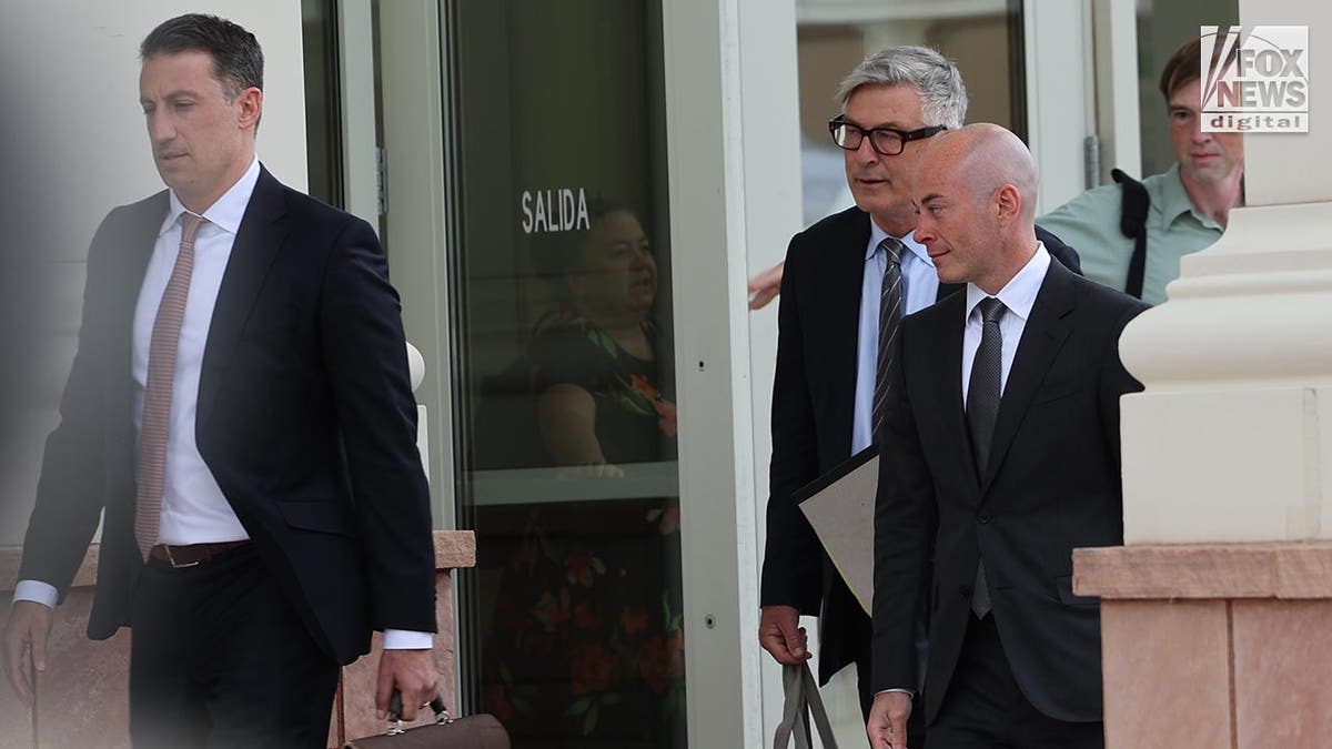 Alec Baldwin in a suit leaves court