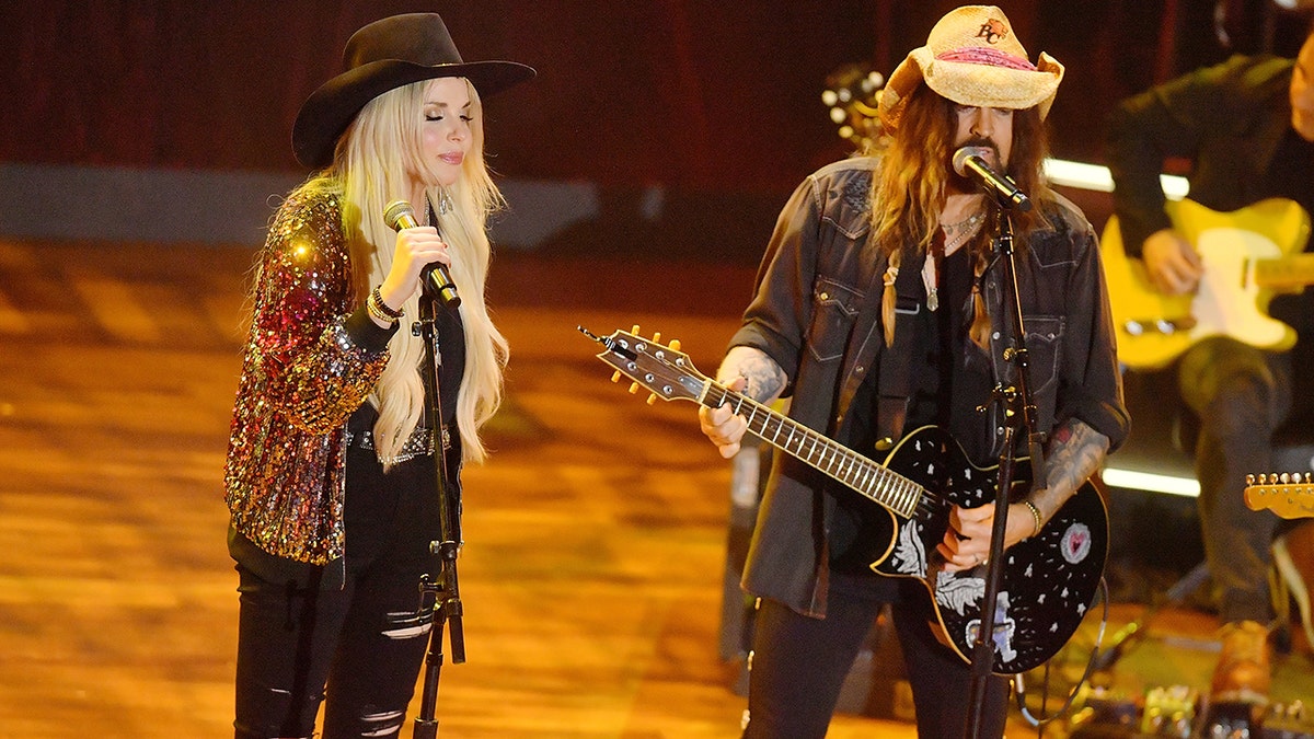 Firerose and Billy Ray Cyrus sing on stage at the Academy of Country Music Honors