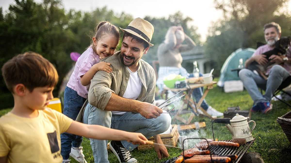 Family cooking on the fire while camping