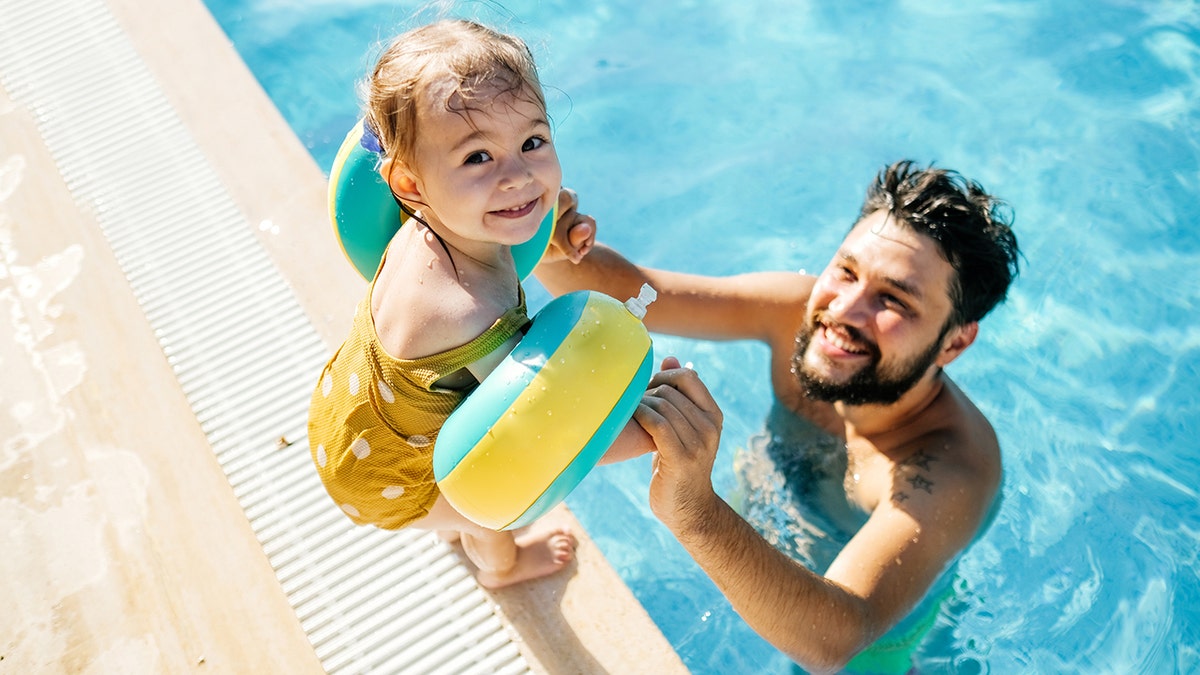 dad with young child in pool