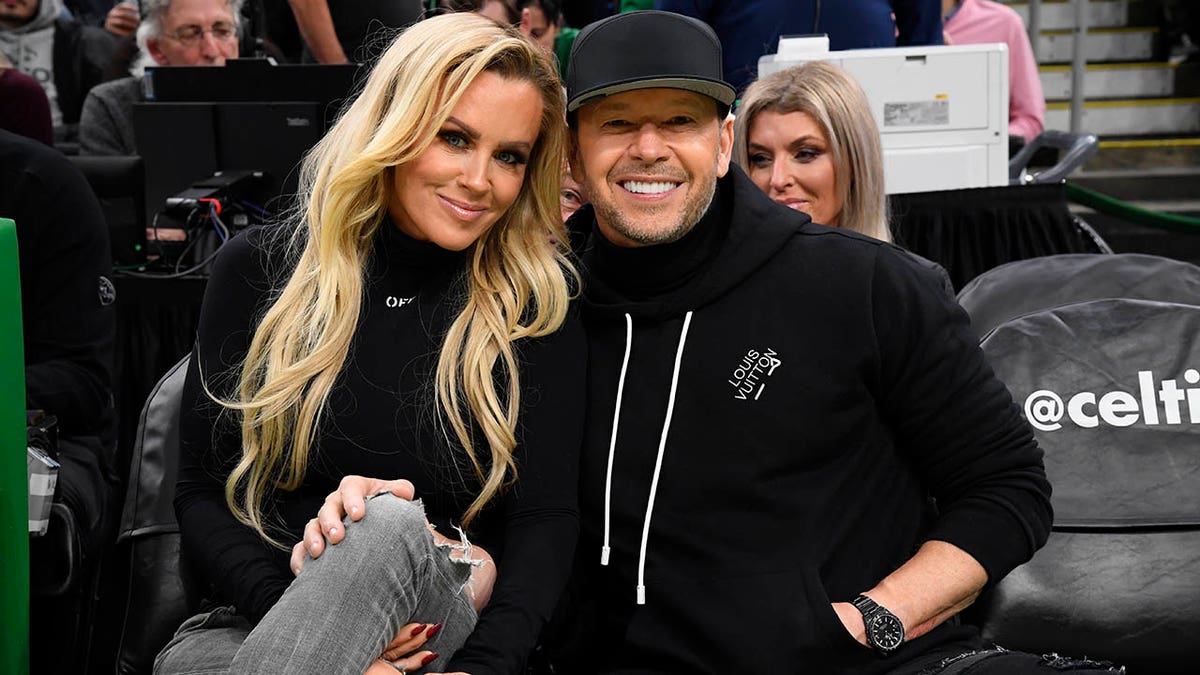 donnie wahlberg and jenny mccarthy smiling at game
