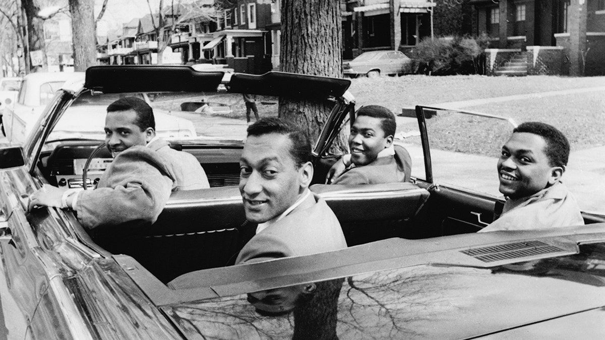 Four Tops pose for photos in a car