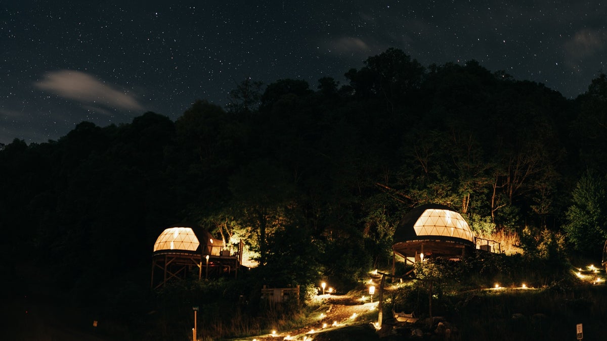 The Glamping Collective resort in North Carolina lit up at night. 