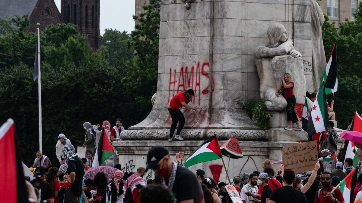 Protester tags "Hamas is Coming" on a Union Station statue