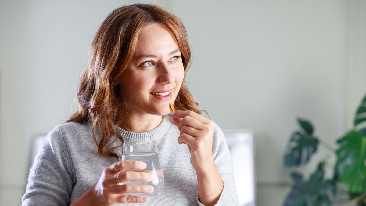 woman taking pill with water