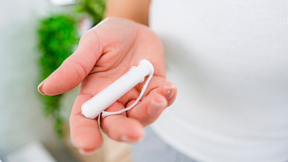 Close up of woman's hand holding a tampon