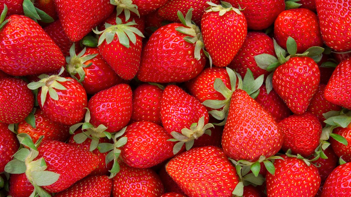 Fresh strawberries that take up the entire frame.