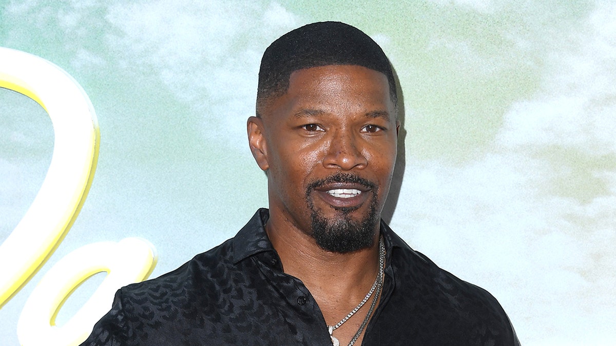 Aktor Jamie Foxx mengenakan kemeja berkancing hitam di karpet merah