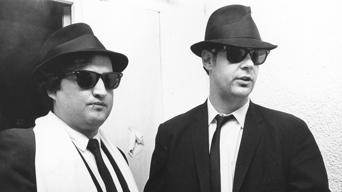Jim Belushi and Dan Aykroyd wear black suits as the Blues Brothers.