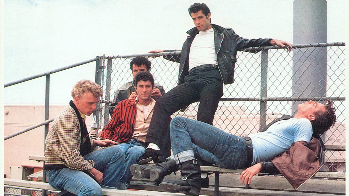 John Travolta and friends on bleachers in scene from "Grease" 