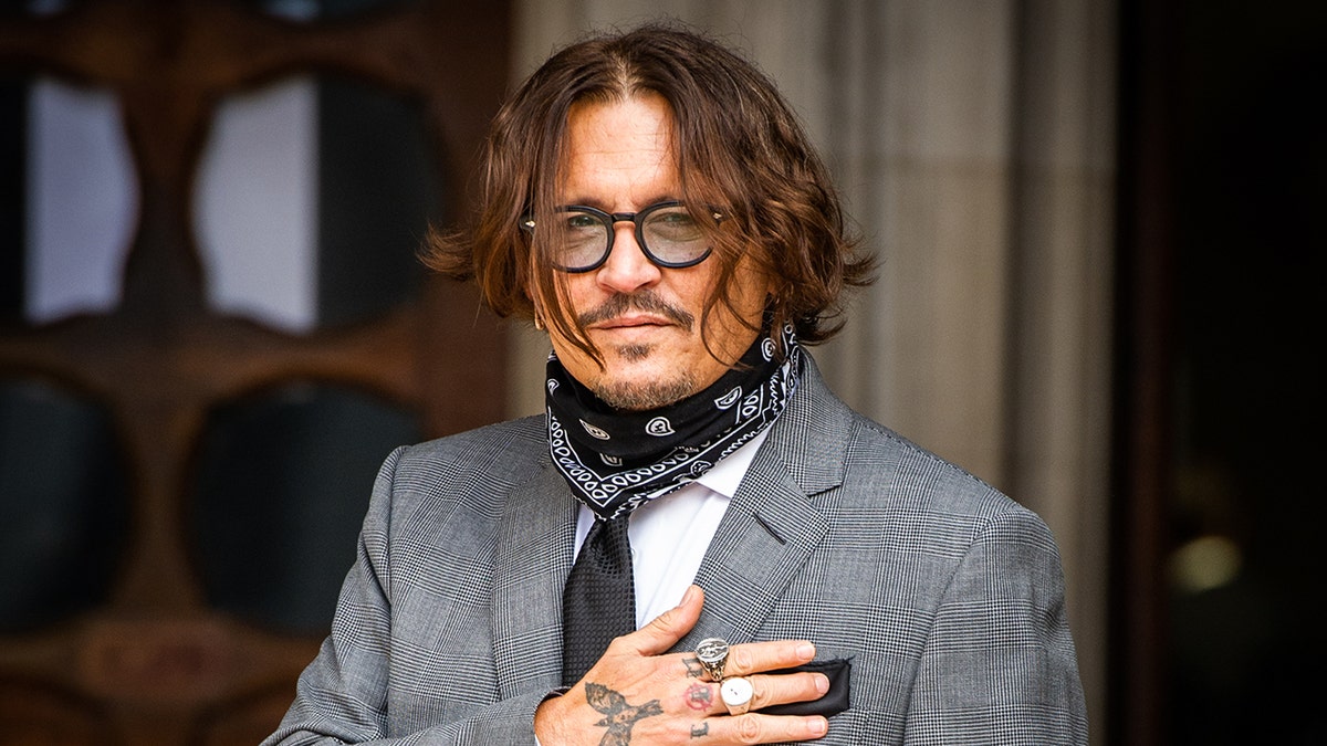 Actor Johnny Depp wears grey plaid blazer with black tie