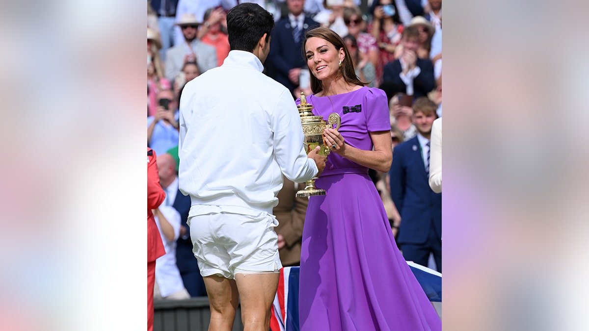 La princesa Catalina, con un vestido morado, entrega a Carlos Alcaraz su trofeo en Wimbledon 2024