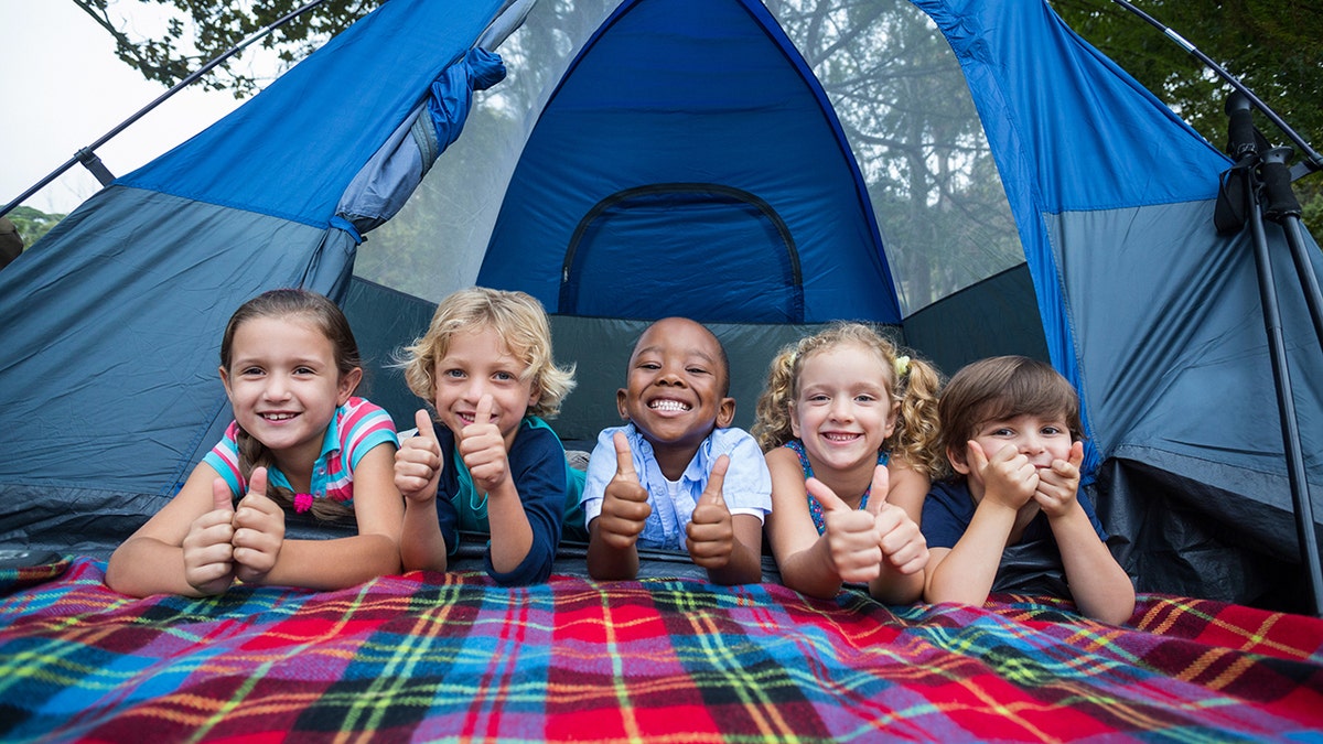 Kids smiling outside a tent