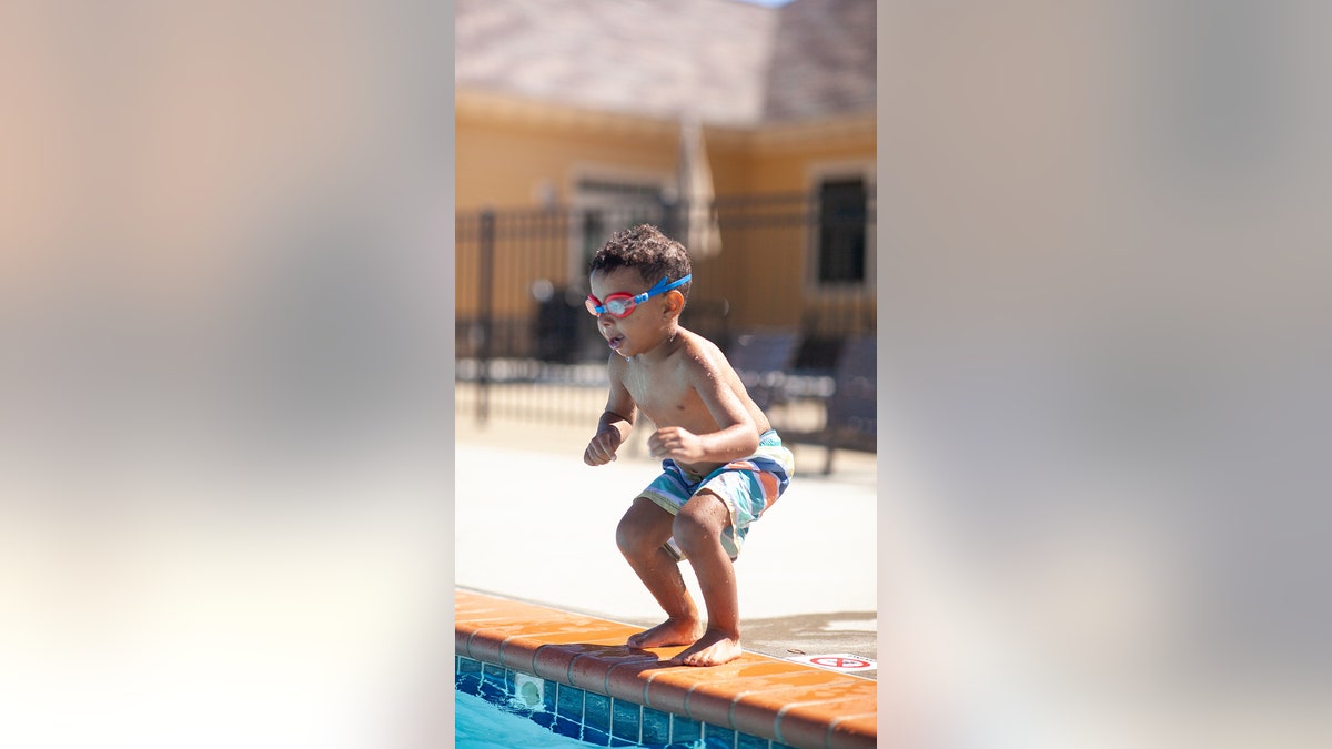 little boy jumping in pool without floaties