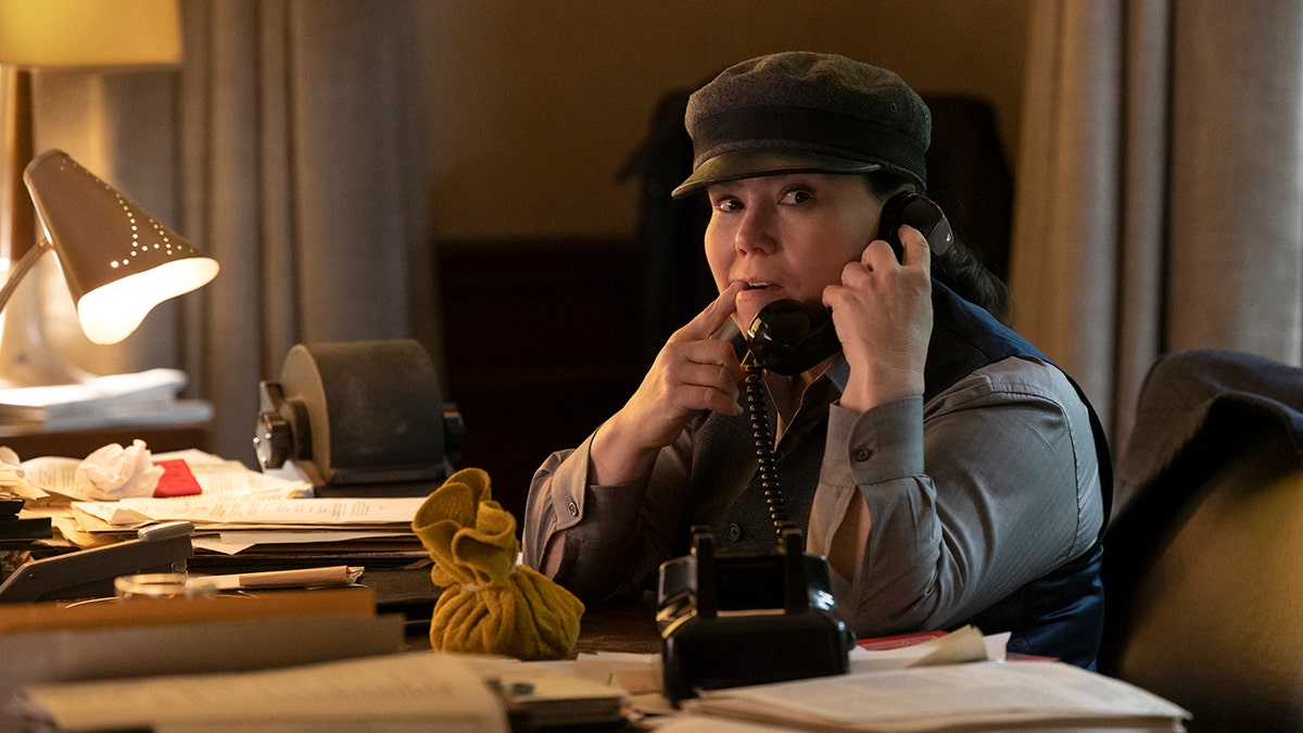 Alex Borstein in a writer's cap holds up the phone in "The Marvelous Mrs. Maisel"