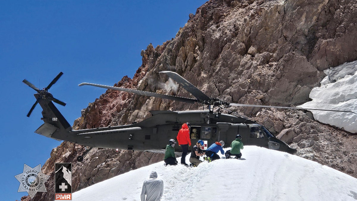 rescuers approaching National Guard helicopter on mountain