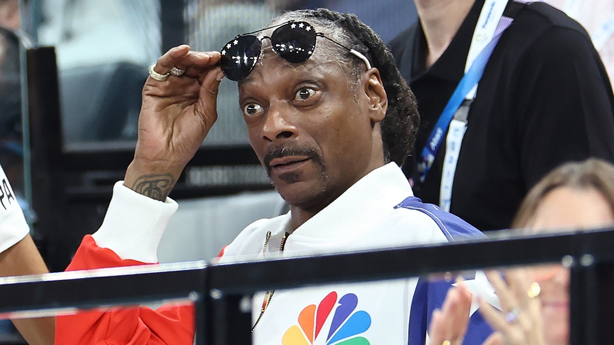 Snoop Dogg raises his glasses and eyebrows while watching the Olympics