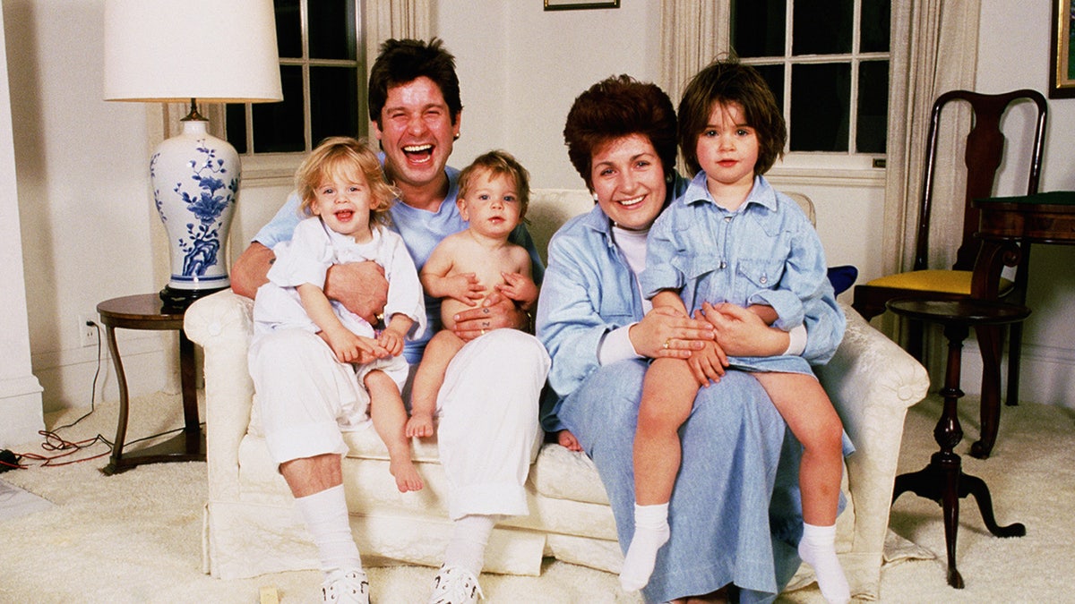 Sharon and Ozzy Osbourne holding their young children in the early 1990s