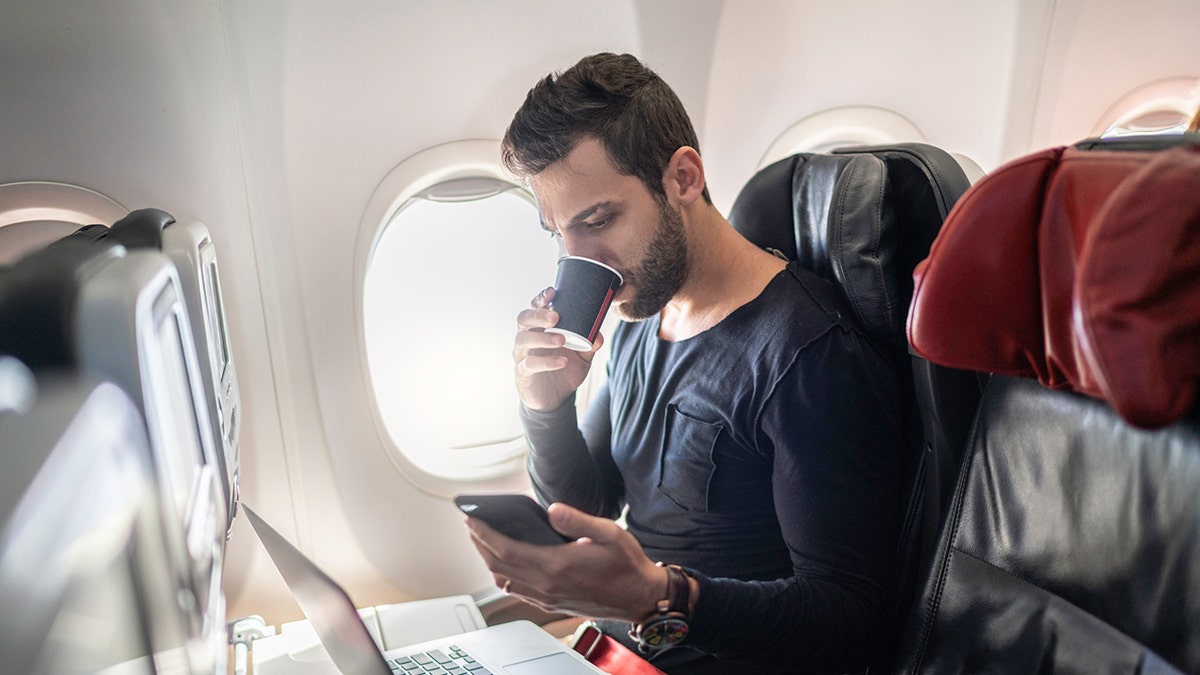 Man drinking coffee on a plane