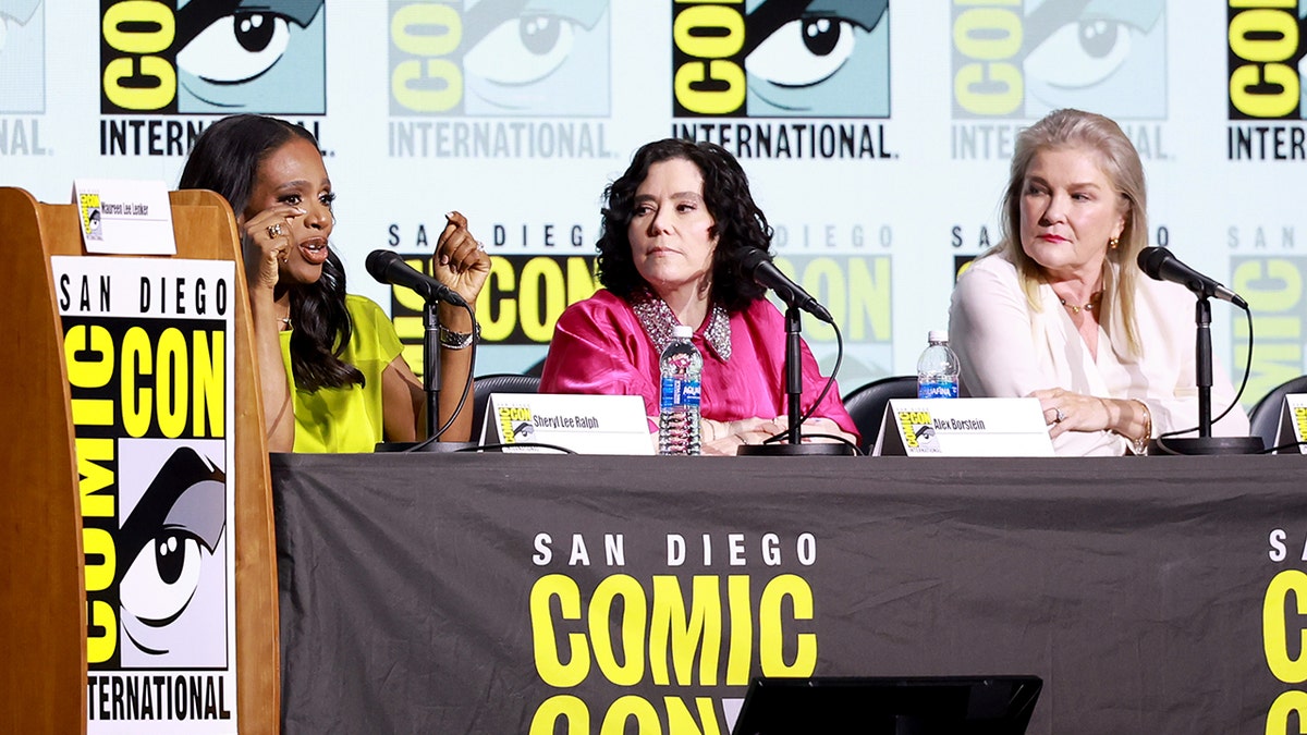 Sheryl Lee Ralph in a neon yellow shirt sits next to Alex Borstein in bright pink next to Kate Mulgrew in light pink at San Diego Comic Con