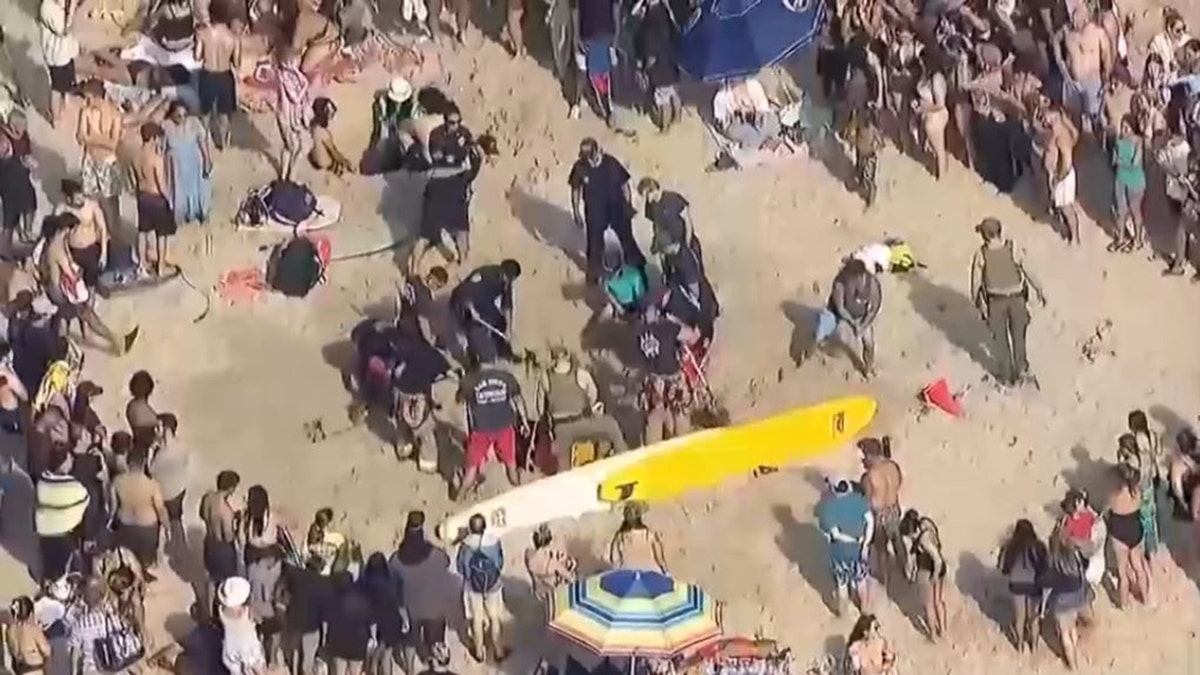 rescuers digging out teen at beach
