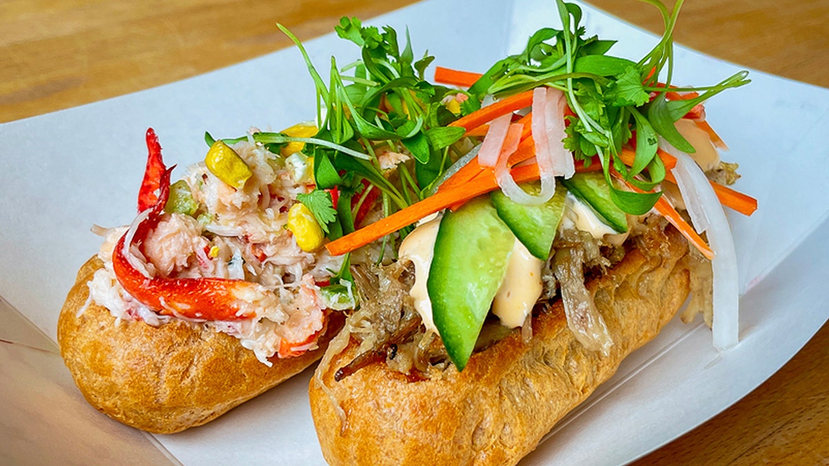 Image of two "savory eclair" pastries. One with lobster. One with banh mi ingredients.