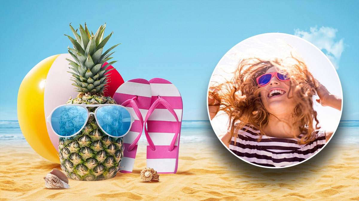 A beach ball, pineapple and flip flops on beach sand and a cheerfully woman enjoying time outside