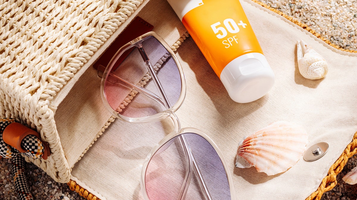 Sunglasses and sunscreen coming out of a bag