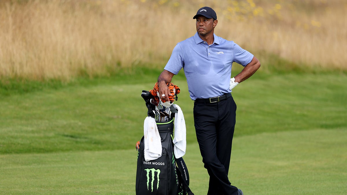 Tiger Woods leans on his bag