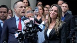 Karen Read smiles as defense attorney David Yannett speaks to reporters in front of Norfolk Superior Court