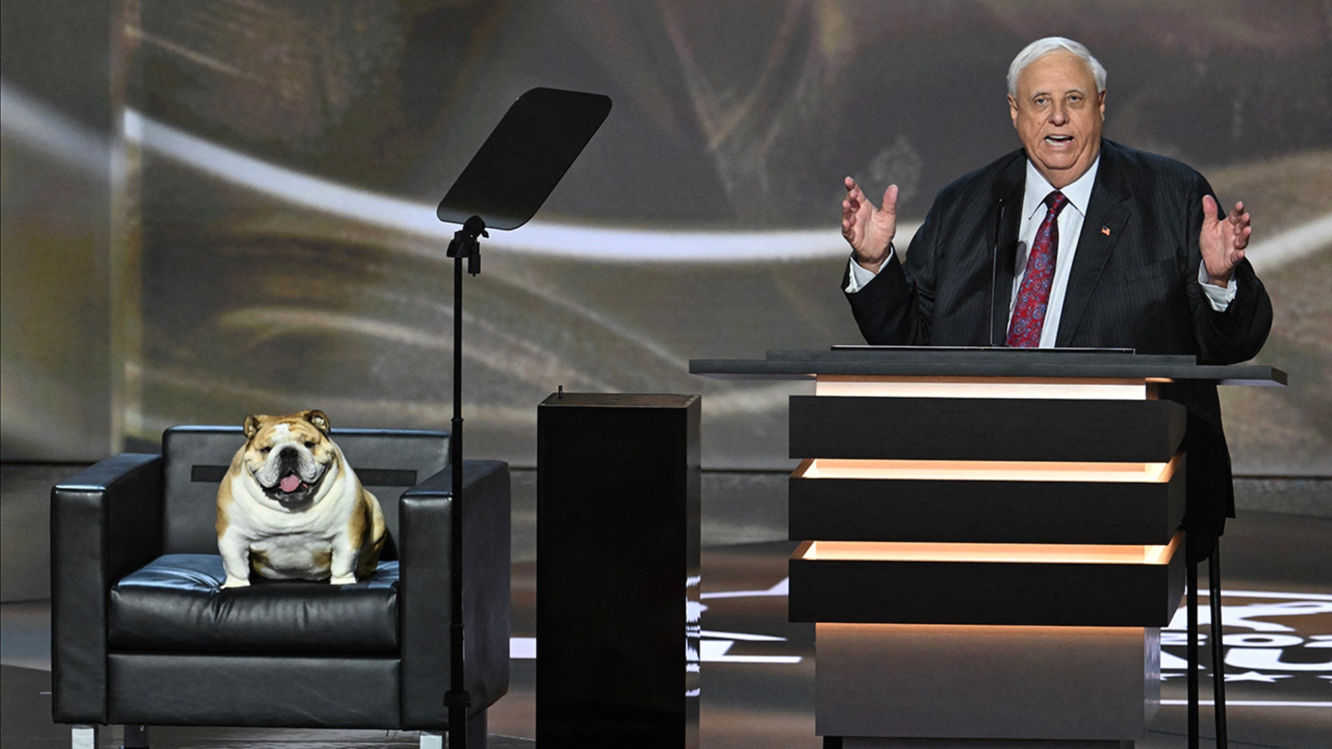 West Virginia Governor Jim Justice speaks alongside his bulldog "Babydog" during the second day of the 2024 Republican National Convention