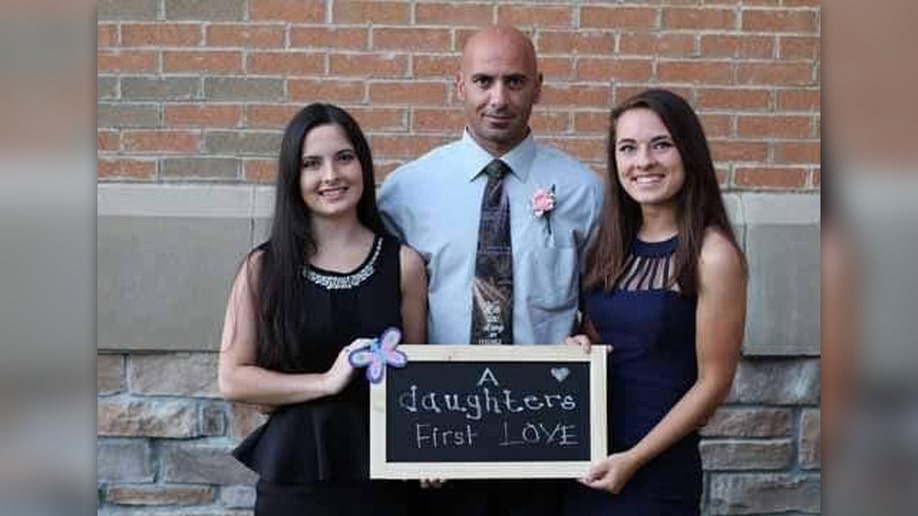 Comperatore and daughters holding a sign calling their dad their 