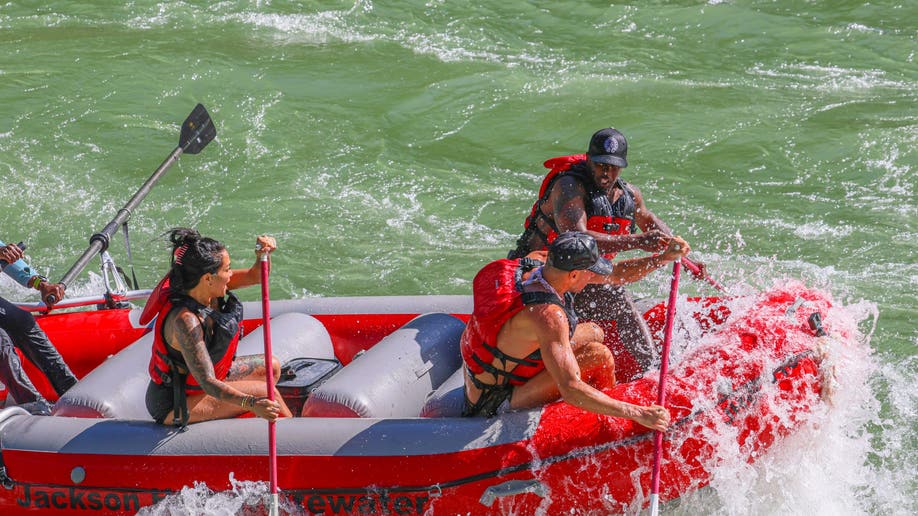 Sean "Diddy" Combs paddling while white water rafting