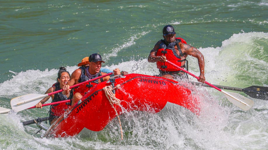 Sean "Diddy" Combs steering while white water rafting