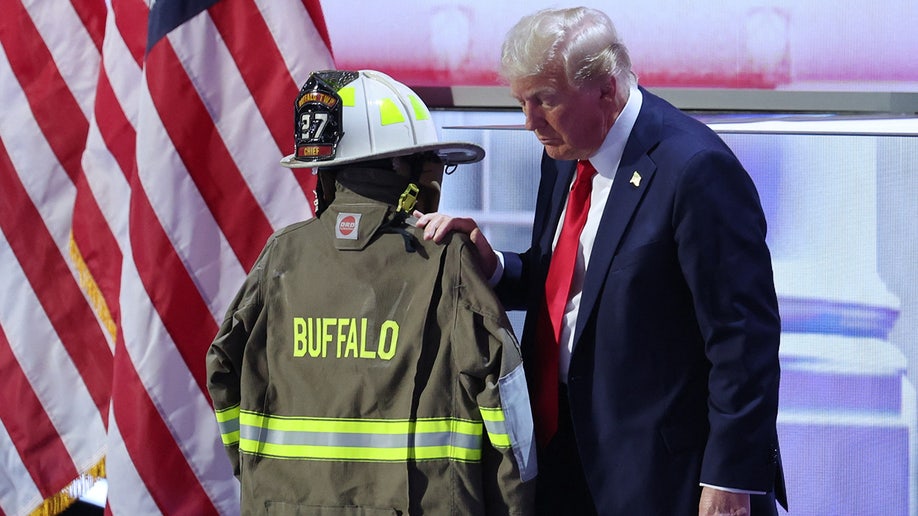 Republican presidential nominee and former U.S. President Donald Trump touches the turnout coat of former Buffalo Township Volunteer Fire Department chief Corey Comperatore