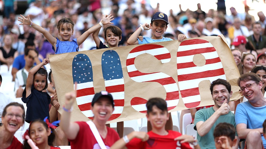 Młodzi fani USA z tabliczką