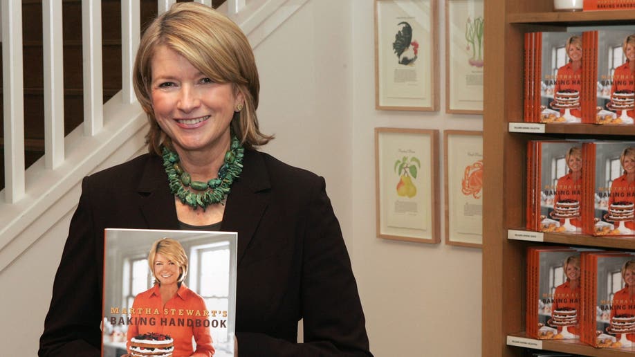 Martha Stewart holding up a book she wrote