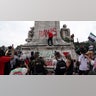 A pro-Palestinian demonstrator sprays graffiti on Christopher Columbus Memorial Fountain at Union Station