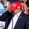 Donald Trump reacts as multiple shots rang out during a campaign rally