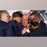 Donald Trump gestures with a bloodied face as multiple shots rang out during a campaign rally
