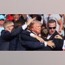 Donald Trump gestures with a bloodied face as multiple shots rang out during a campaign rally